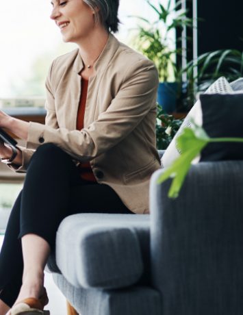 old-woman-sitting-in-a-room-holding-a-tablet